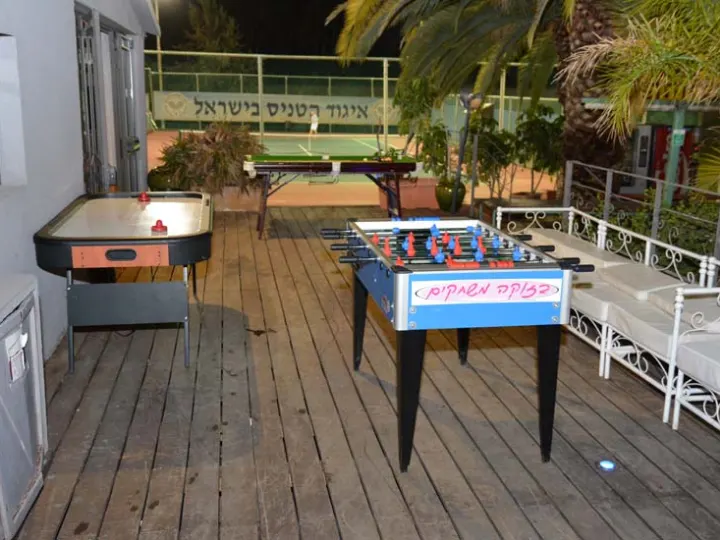 אורחים סביב שולחן הוקי אוויר על מרפסת באירוע
